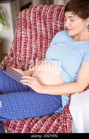 Pregnant woman using tablet pc Banque D'Images