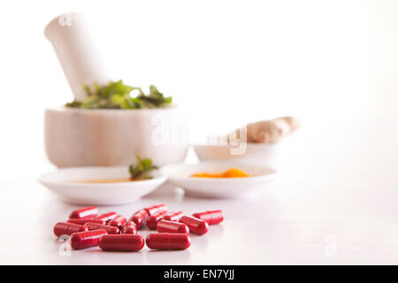 Produits à base de plantes et de la médecine grinder avec capsules isolé sur fond blanc Banque D'Images