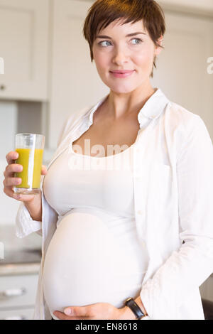 Femme enceinte avec un verre de jus d'orange Banque D'Images