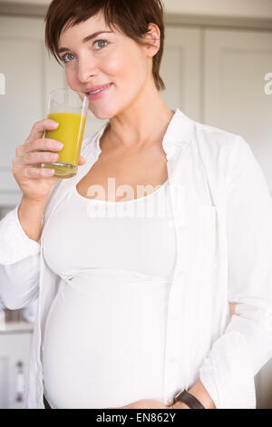 Femme enceinte de boire dans un verre de jus d'orange Banque D'Images