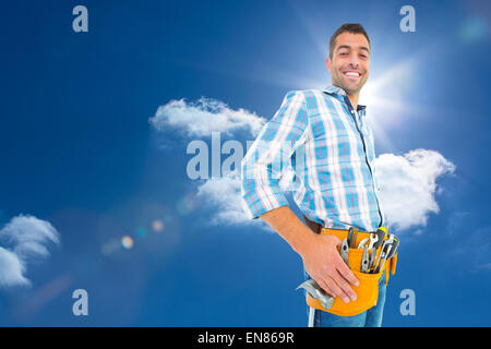 Image composite de portrait of smiling handyman wearing tool belt Banque D'Images