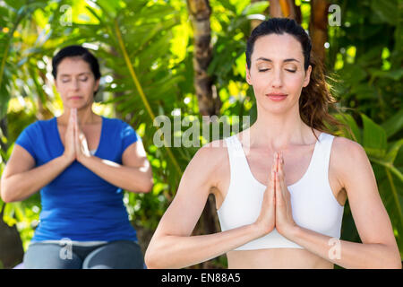 Son entraîneur et Relaxed woman doing yoga Banque D'Images