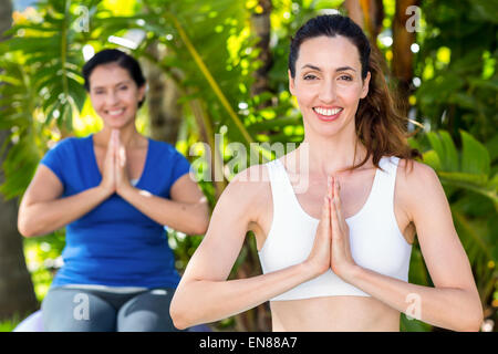 Son entraîneur et Relaxed woman doing yoga Banque D'Images