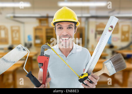 Image composite de portrait of happy worker holding divers équipements Banque D'Images