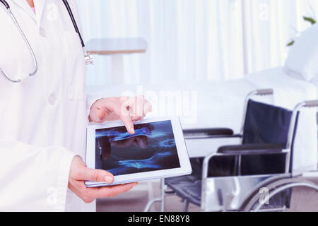 Image composite de doctor looking at xray sur tablette Banque D'Images