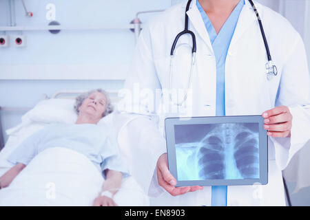 Image composite de doctor looking at xray sur tablette Banque D'Images