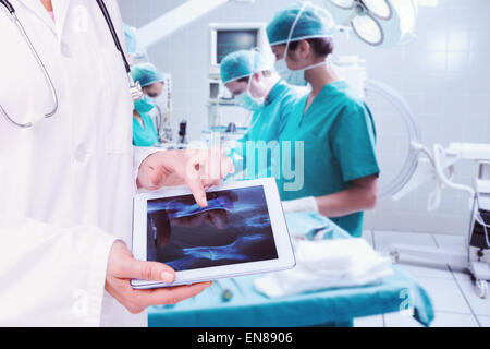 Image composite de doctor looking at xray sur tablette Banque D'Images