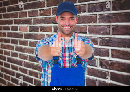Image composite de portrait of happy homme réparateur gesturing Thumbs up Banque D'Images