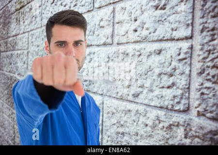 Composite image young male mechanic holding spanner Banque D'Images