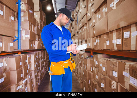 Image composite de handyman in blue dans l'ensemble writing on clipboard Banque D'Images