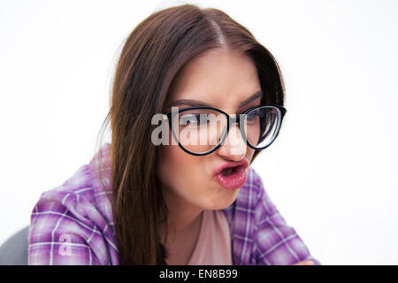 Closeup portrait of a young woman in glasses making funny face, avec white backgorund Banque D'Images