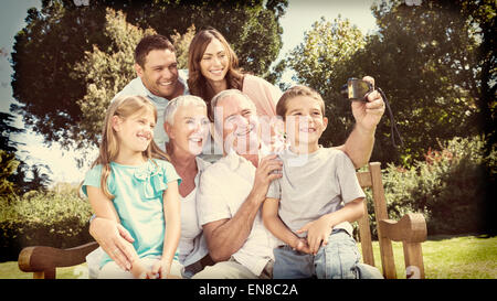 Assis sur un banc de la famille taking photo d'eux-mêmes Banque D'Images