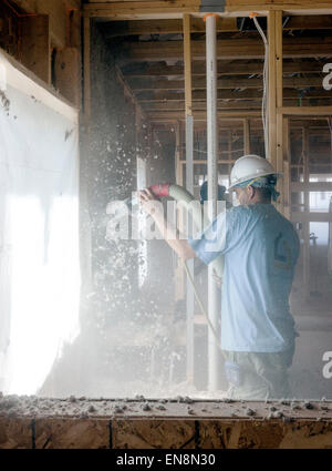 La pulvérisation des travailleurs de cellulose dans les murs d'une nouvelle maison en construction Banque D'Images