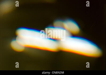 La fin de journée la lumière du soleil réfractée à travers un vitrail, verre au plomb fenêtre crée un prisme de couleur sur un tapis Banque D'Images