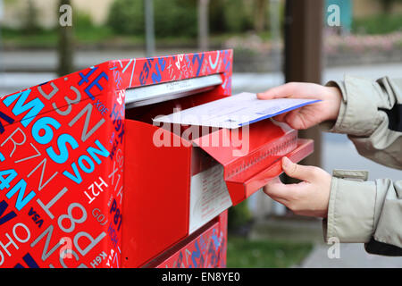 Part de l'envoi d'un rapport d'impôt lettre dans une boîte aux lettres rouge Banque D'Images