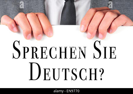 Un homme portant un costume avec une pancarte portant la phrase Sprechen Sie Deutsch ? Parlez-vous allemand ? Écrit en allemand sur elle Banque D'Images