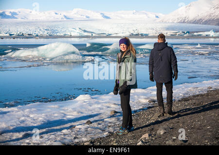 Couple de touristes à la lagune Glaciaire de Jokulsarlon, au bord du parc national de Vatnajokull, Islande en février Banque D'Images