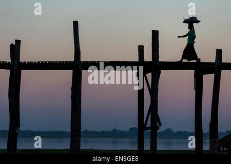 Les personnes qui traversent le pont en bois au coucher du soleil, U Bein bridge, Mandalay, Myanmar. Banque D'Images
