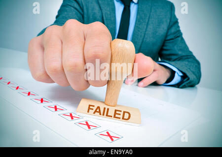 Un jeune homme de race blanche à son bureau bureau avec un tampon de caoutchouc avec le mot n Banque D'Images
