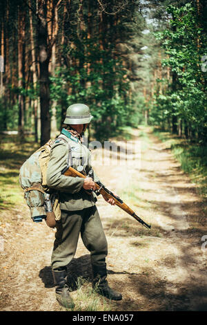 La reconstitution médiévale non identifiés habillés en soldat allemand pendant les mois de mars à travers la forêt de l'été. Reconstitution historique Banque D'Images