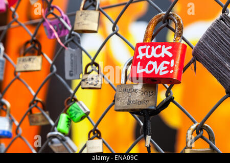 L'amour des verrous sur une chaîne de sécurité muni d'un cadenas rouge vif avec des mots de rejet de l'amour, la clôture est près de Fort Park, London Shoreditch Banque D'Images