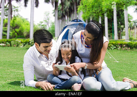 Les parents indiens avec fille park playing Video Game Banque D'Images