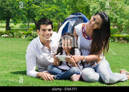 Les parents indiens avec fille park playing Video Game Banque D'Images