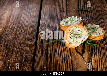 Sandwich au beurre d'herbes et de romarin sur fond de bois rustique Banque D'Images