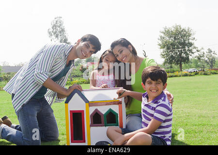 Les parents et les enfants indiens montrant parc maison factice Banque D'Images