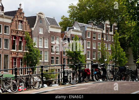 Prêt de vélos stationnés sur un pont sur un canal à Amsterdam Hollande Pays-bas Europe Banque D'Images