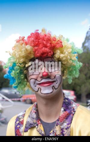 Le clown qui marche dans la rue et amuse les enfants. Banque D'Images