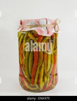 Un pot de piments faites maison dans une solution de vinaigre, eau et sel. Banque D'Images