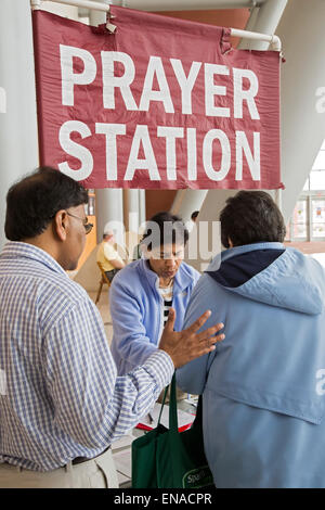 Warren, Michigan USA - militants chrétiens prient avec une femme à leur prière 'gare' dans le hall de l'hôtel de ville. A quelques pas, les athées personnel un « raison.' a l'origine, la ville autorisé que la prière. Il a fallu une décision de la Cour fédérale afin de permettre les athées pour configurer leur table. Crédit : Jim West/Alamy Live News Banque D'Images