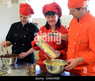 Oldisleben, Allemagne. 10 avr, 2015. Chef d'entreprise, Karin doigt (C), chef de cuisine, Marko Schnitter, et chef, Viktoria Steinwachs, préparer différents chocolats pour les pralines et les hauts talons dans la fabrique de chocolat de Goethe dans Oldisleben, Allemagne, 10 avril 2015. Les chaussures à talons hauts en couleurs font partie de la vaste et de grande qualité production praline dans son entreprise, qui a été fondée il y a dix ans. Photo : WALTRAUD GRUBITZSCH/dpa/Alamy Live News Banque D'Images