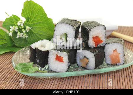 Un bol en verre avec des sushis et des feuilles de wasabi Banque D'Images