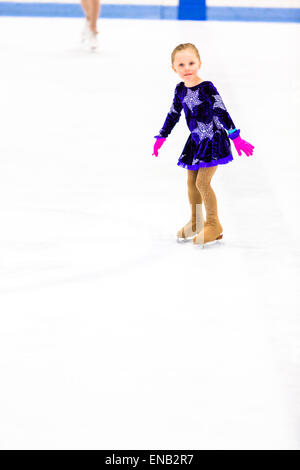La patineuse artistique jeunes exerçant devant son premier ccompetition. Banque D'Images