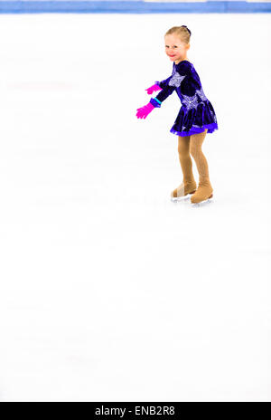 La patineuse artistique jeunes exerçant devant son premier ccompetition. Banque D'Images