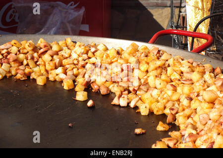 Cubes de pommes de terre au four assaisonnée, morceaux, dans une grande poêle sur la rue du marché, de l'Espagne. Banque D'Images