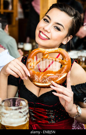 Woman in Dirndl Oktoberfest bretzel manger Banque D'Images