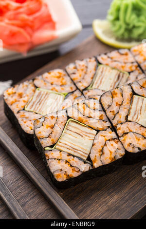 Futomaki avec tobico et tomago omelette sur une planche en bois Banque D'Images