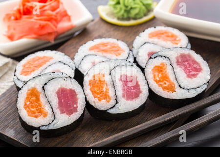 Yin Yang futomaki avec le thon et le saumon sur une planche en bois Banque D'Images