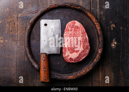 Frais crus de viande marbrée Black Angus Steak Ribeye et viande cleaver sur fond sombre Banque D'Images