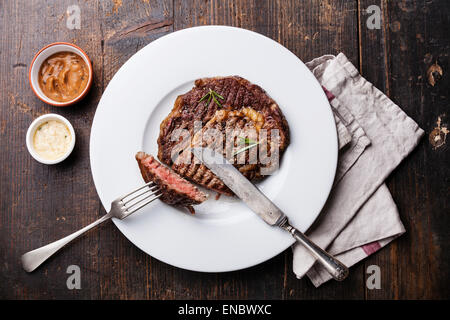 Black Angus Steak grillé sur plaque avec sauce au poivre épicé sur fond de bois Banque D'Images