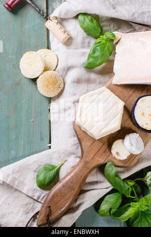 Variation du fromage, servi sur planche à découper en bois avec le basilic et breadover turquoise table en bois. Voir la série Banque D'Images