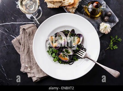 Pâtes aux fruits de mer Spaghetti aux palourdes Vongole sur plaque blanche sur fond de marbre noir Banque D'Images