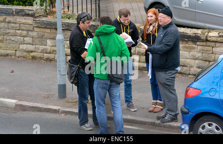 Manchester UK 2 mai 2015 Candidat parlementaire Libdem, John Leech, portant une cagoule verte, des mémoires de ses partisans qu'ils répondent dans une rue Didsbury avant de livrer des feuillets aux maisons dans la région. John a remporté en 2005 et 2010, mais le travail est prévu pour les faire fonctionner très proche cette fois. Les conservateurs n'ont pas de chance. Campagne pour l'élection générale dans LbDem Withington Manchester Crédit : John Fryer/Alamy Live News Banque D'Images