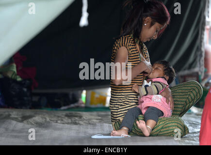 Katmandou, Népal. 2 mai, 2015. Une femme nourrit un bébé à Katmandou, Népal, le 2 mai 2015. Le bilan de l'édition de samedi dernier du puissant tremblement de terre au Népal a atteint 6 659 et un total de 14 062 autres ont été blessés, le ministère d'accueil du pays a déclaré samedi. Credit : Qin Qing/Xinhua/Alamy Live News