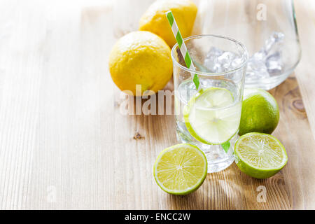 Un verre de limonade avec paille papier rayé avec les feuilles de menthe et citron vert frais Banque D'Images