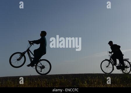 Herat, Afghanistan. 2 mai, 2015. De jeunes Afghans faire du vélo le long d'une route dans la province d'Hérat, à l'ouest de l'Afghanistan, le 2 mai 2015. © Sardar/Xinhua/Alamy Live News Banque D'Images