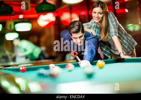 Jeune couple playing pool Banque D'Images